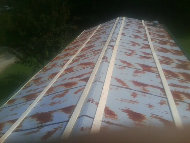 Rusted metal roof panels with new wood purlins before replacement — Storm Damage Roof Repair in Malverne by Roofing Brothers