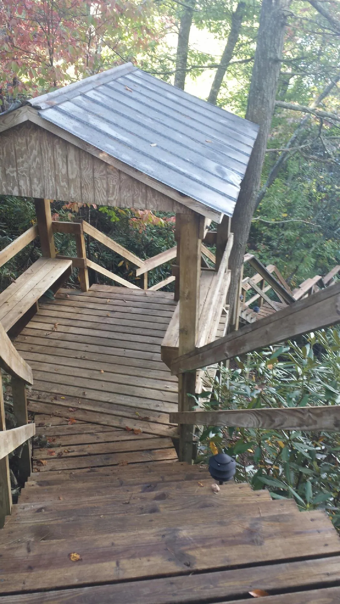 Metal roofed shelter over wooden steps on a wooded walkway — Skylight Repair & Installation work by our crew in Malverne