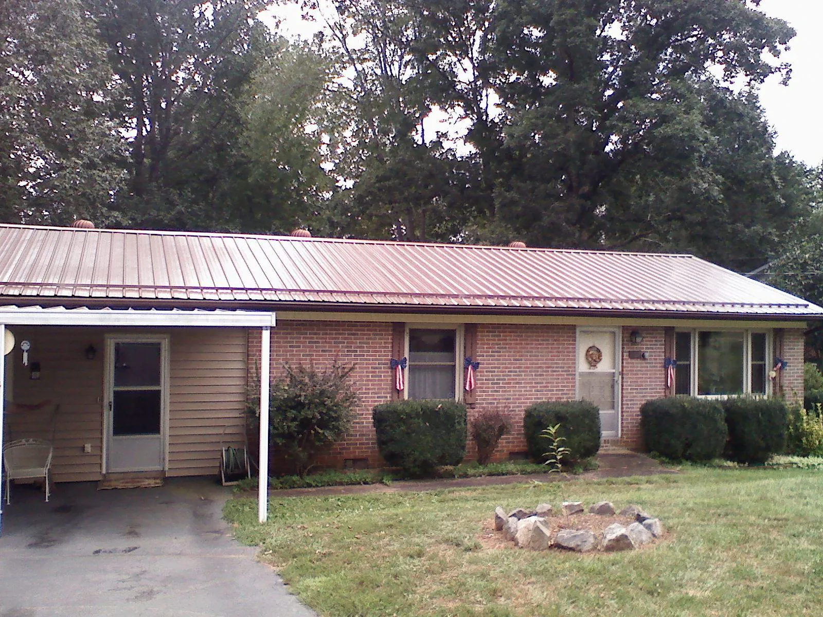 Bronze metal roof and carport on a brick ranch home — Roof Repair work by our crew in Malverne